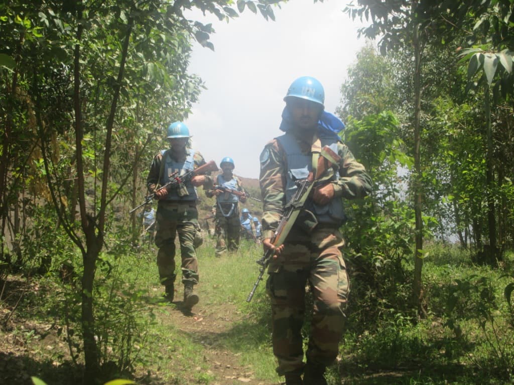 MONUSCO peacekeepers walk in single file along a bush track during a patrol in North Kivu