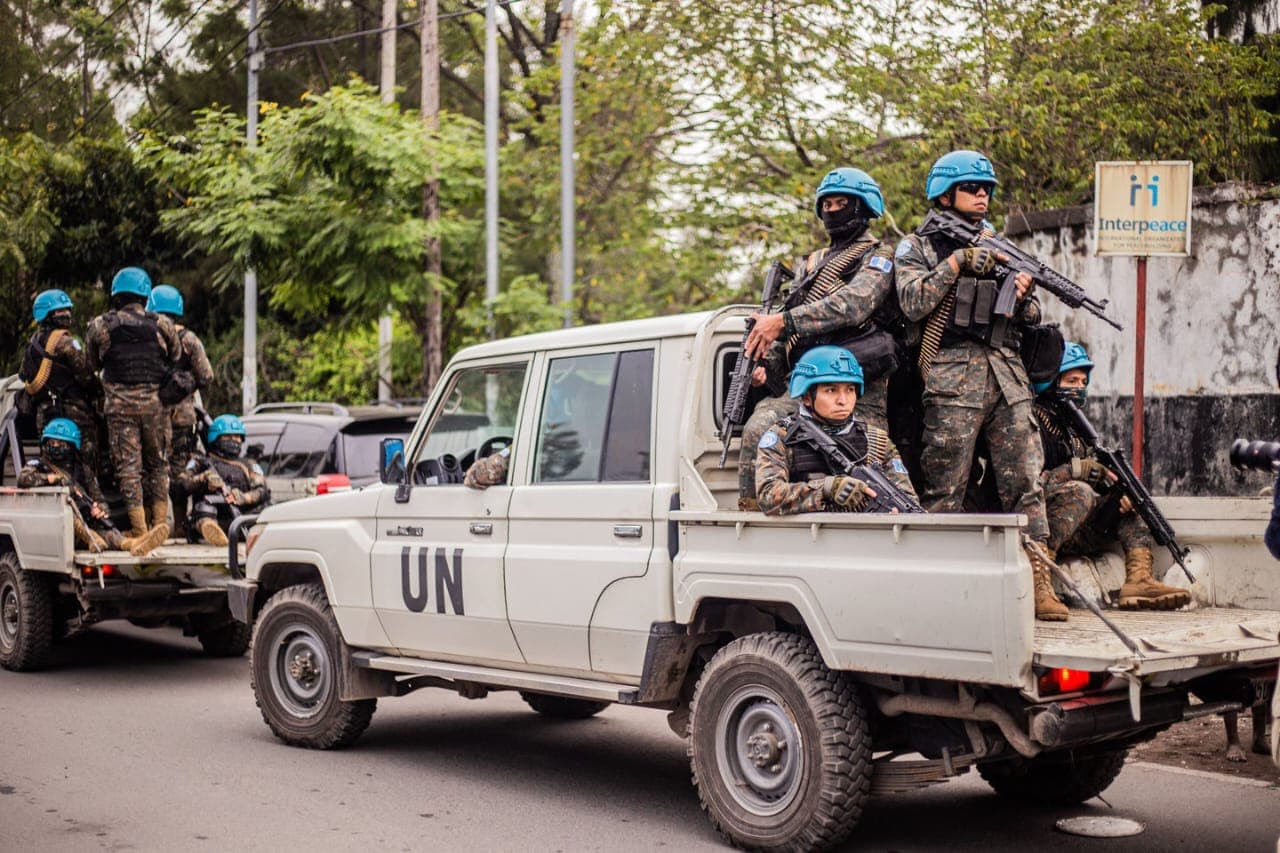 Armed United Nations peacekeepers aboard vehicles marked "UN" in a street in Goma